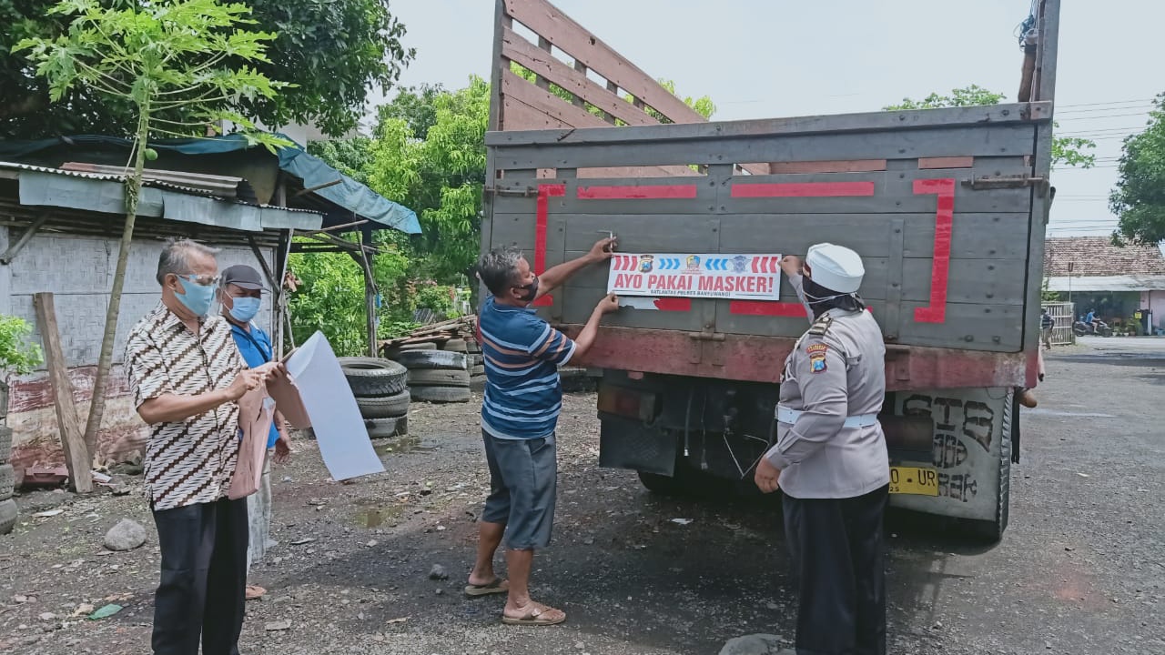 Petugas memasang stiker 'Ayo Pakai Masker' di salah satu truk operasional sebuah perusahaan. (Foto: Istimewa)