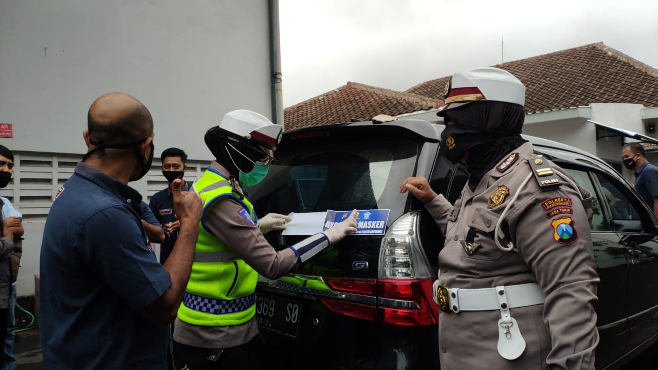 Petugas memasang stiker'Ayo Pakai Masker'pada kendaraan operasional perusahaan produsen rokok. (Foto: istimewa)