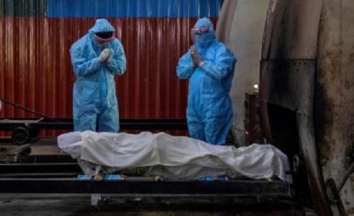 Petugs ksehatan hendak memasukkan jenazah akibat covid untuk dikremasi, di Mumbay, India. (Foto:AFP) 