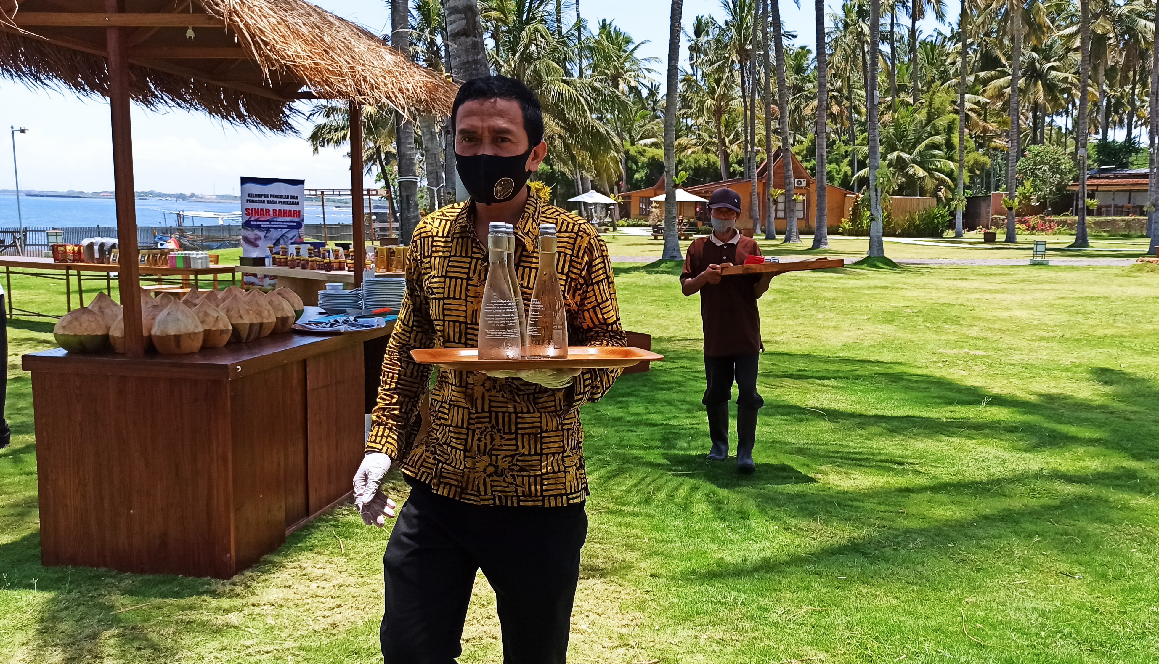 Pegawai Villa So Long mengenakan masker secara lengkap saat melayani tamu. (Foto: Muh. Hujaini/Ngopibareng.id)