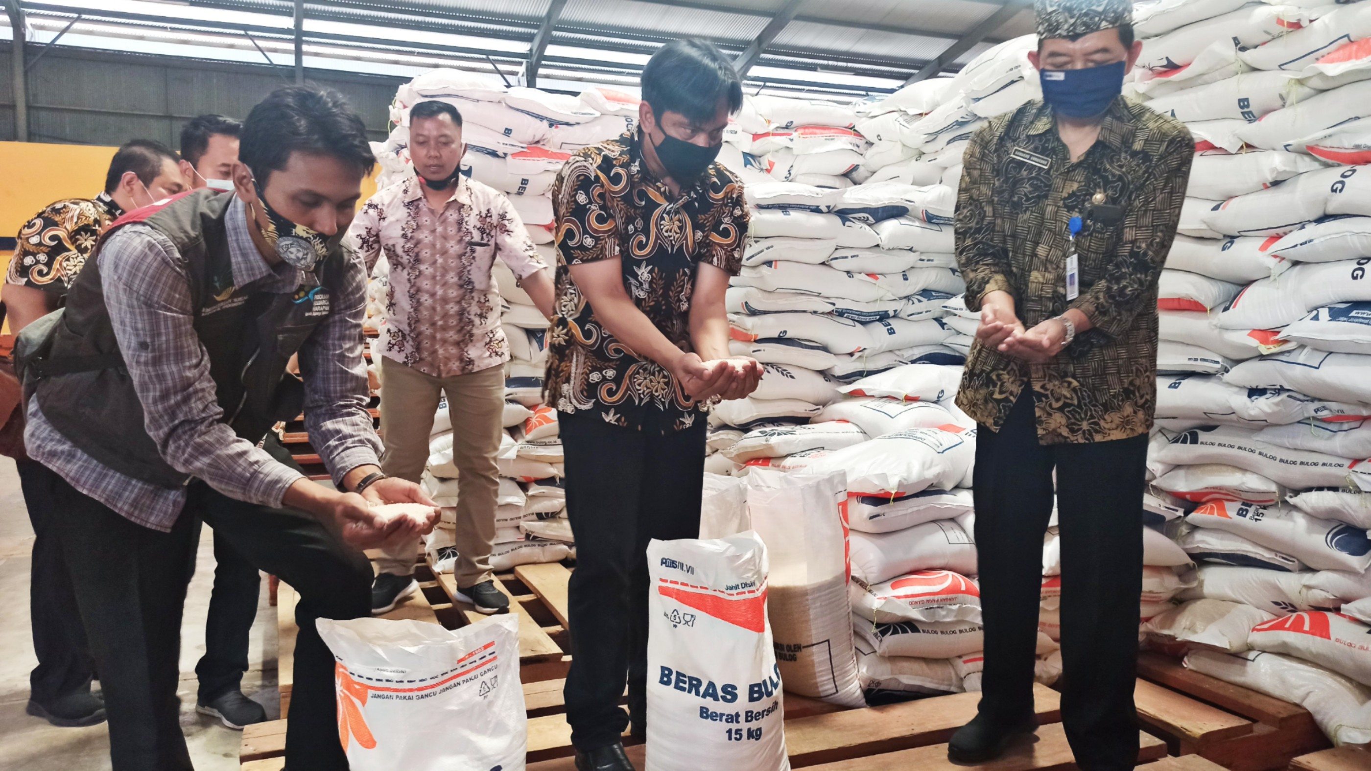 Pimpinan Bulog bersama perwakilan Dinas Sosial dan Pendamping PKH menunjukkan beras yang didistribusikan pada KPM PKH (foto:Muh Hujaini/Ngopibareng.id)