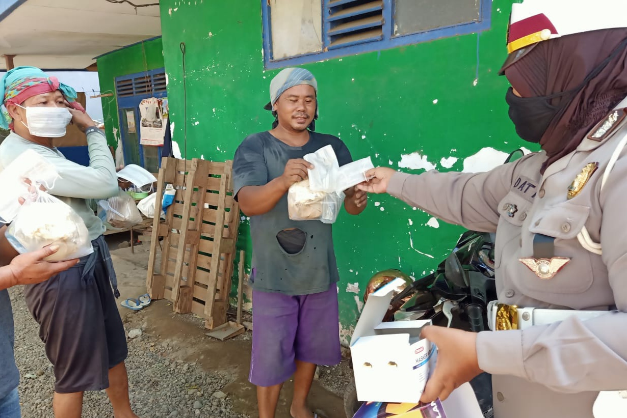 Petugas dari Satlantas Polresta Banyuwangi membagikan masker plus nasi bungkus kepada awak kendaraan ekspedisi. (Foto: Istimewa)