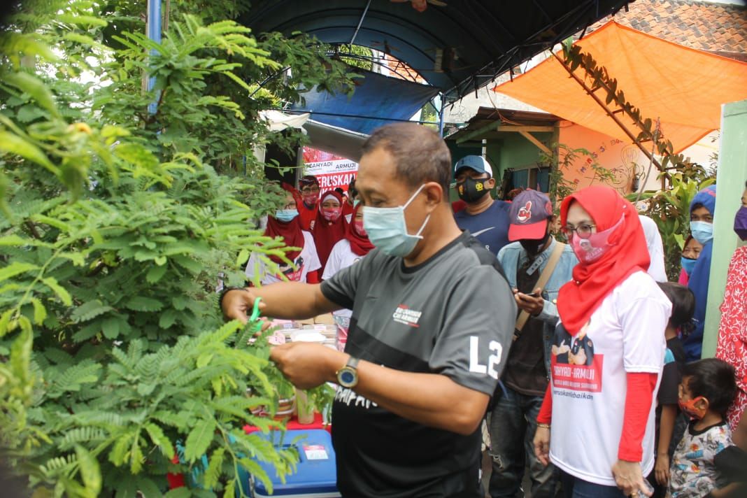 Armuji memetik daun sinom dengan warga Kali Manyar, Surabaya. (Asmanu Sudharso/Ngopibareng.id)