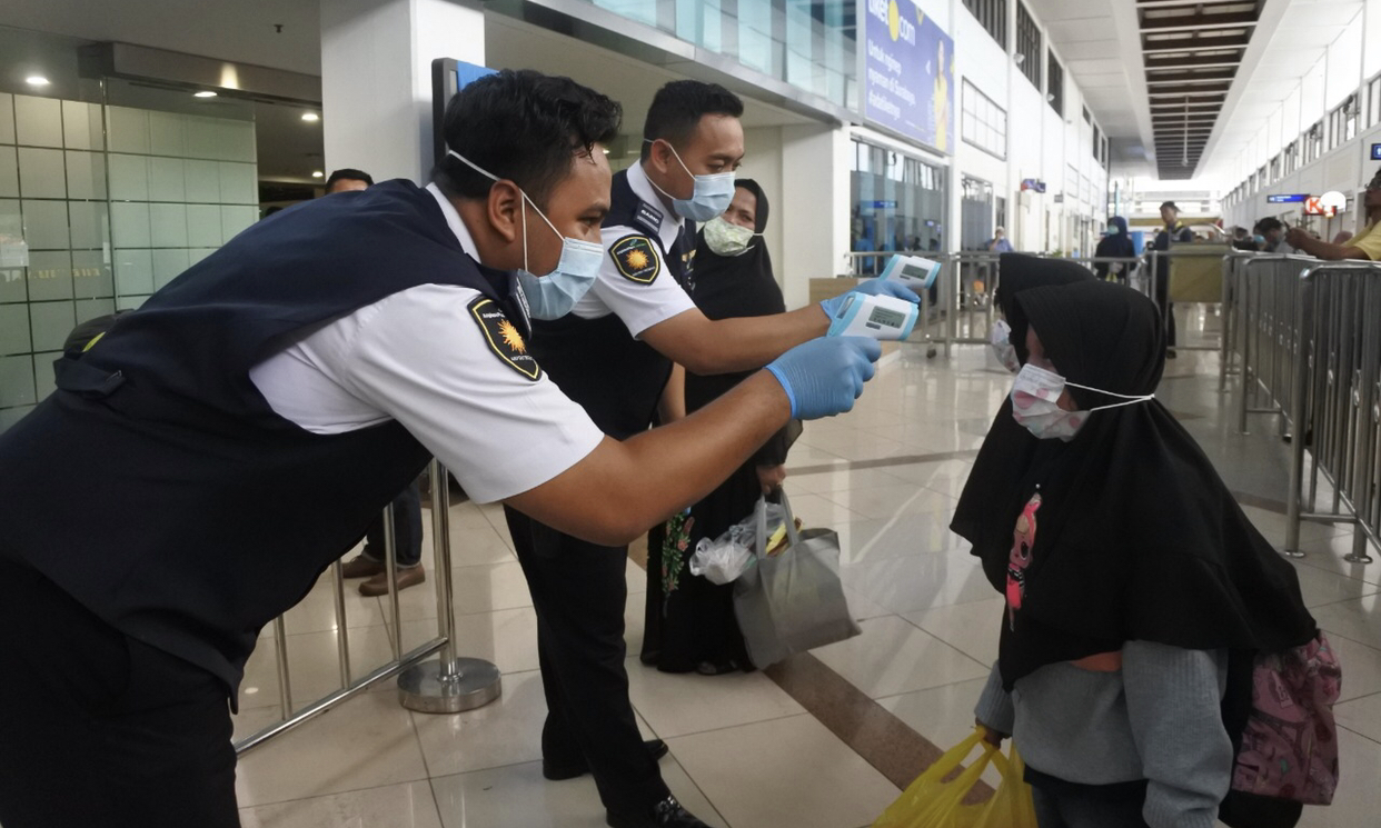 Petugas Bandara Internasional Juanda, ketika melakukan pengecekkan suhu tubuh penumpang. (Foto: Istimewa)