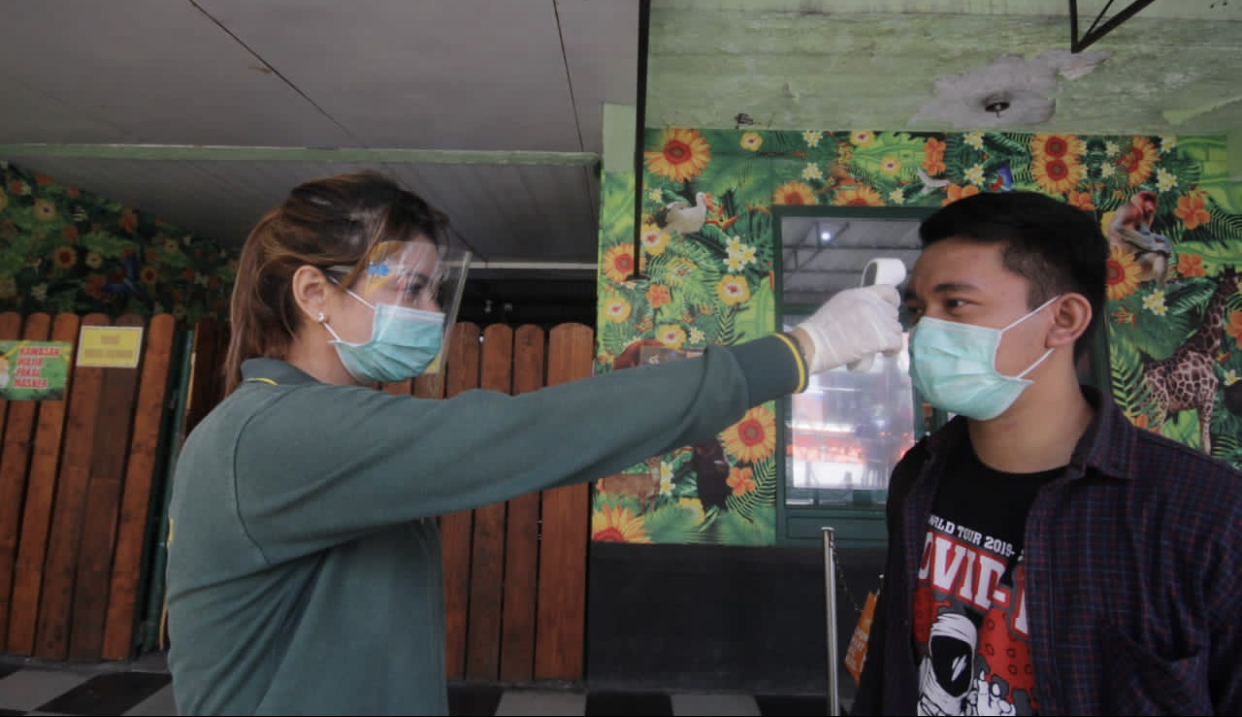Salah satu pengunjung Kebun Binatang Surabaya (KBS) ketika melakukan pengecekkan suhu tubuh di pintu masuk. (Foto: Istimewa)