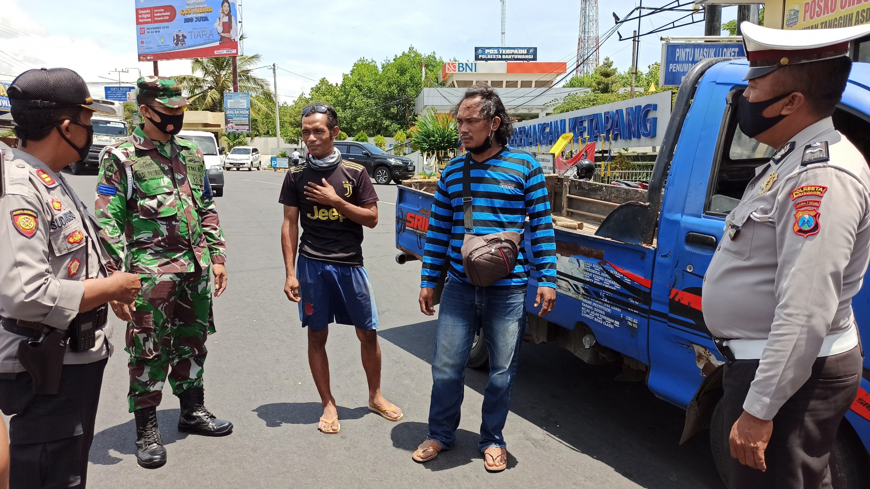 Petugas menegur salah seorang pengendara mobil yang akan menyeberang ke Bali. Mereka mengenakan maskernya di bagian dagu. (Foto: Muh Hujaini/Ngopibareng.id)