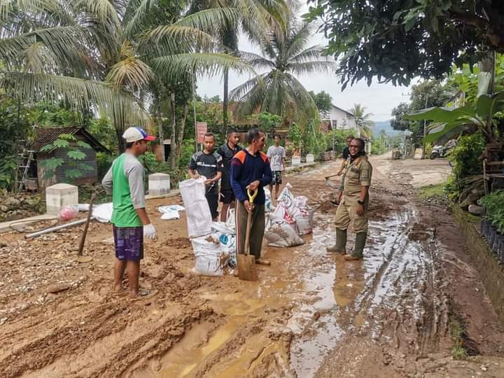 Warga dan BPBD ramai-ramai membersihkan lumpur di jalan sisa banjir bandang yang terjadi Selasa, 27 Oktober 2020 dini hari. (Foto: Dok BPBD Trenggalek)
