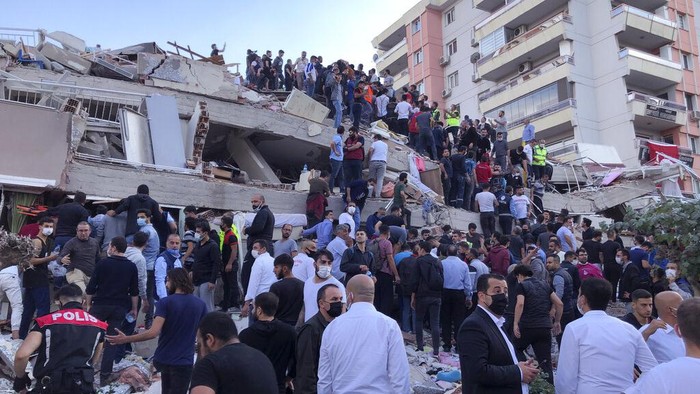 Sejumlah warga mengevakuasi korban gempa di reruntuhan bangunan. (Foto: AP)