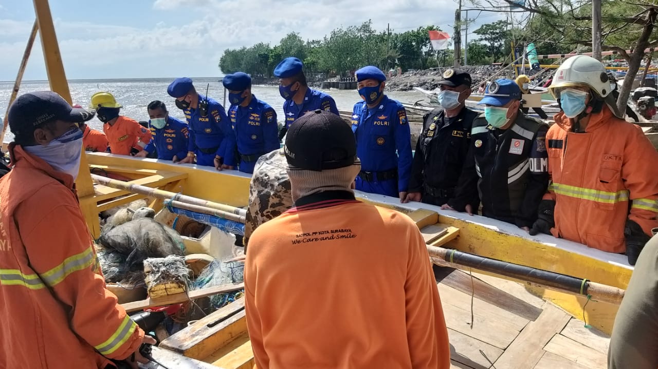 Aparat Ditpolairud Polda Jatim membantu proses evakuasi perahu rusak akibat banjir rob di Kampung Nelayan Nambangan Kenjeran, Surabaya, Kamis 12 November 2020. (Foto: Polda Jatim)