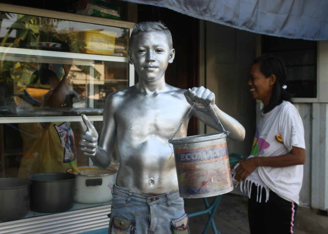 Remaja dengan bubuk silver di sekujur tubuhnya. Selain untuk menarik perhatian juga untuk mengurangi rasa malu. (Foto: Asmanu Sudharso/Ngopibareng.id)
