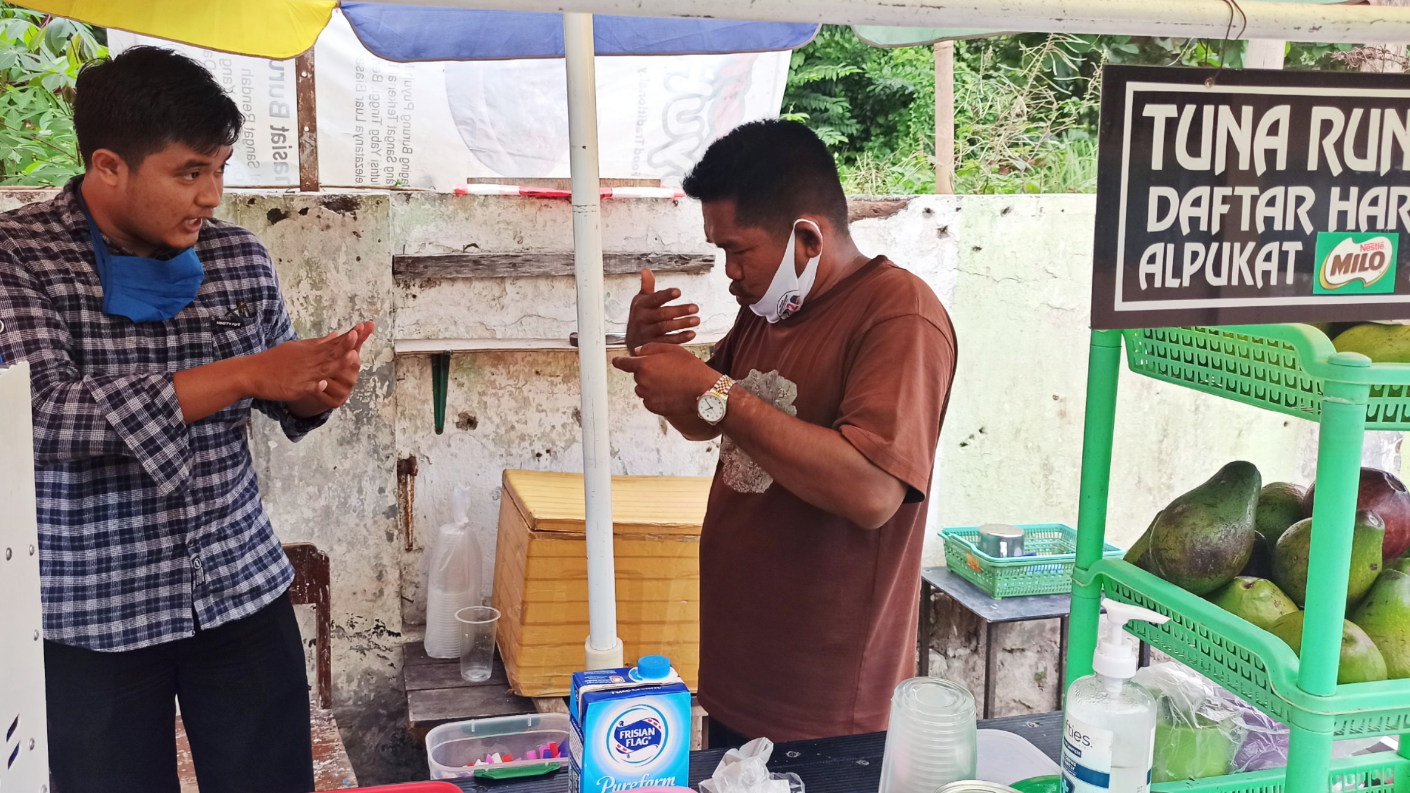 Alvian Krisna (baju kotak) berbincang dengan Suyono menggunakan bahasa isyarat (foto:Muh Hujaini/Ngopibareng.id)