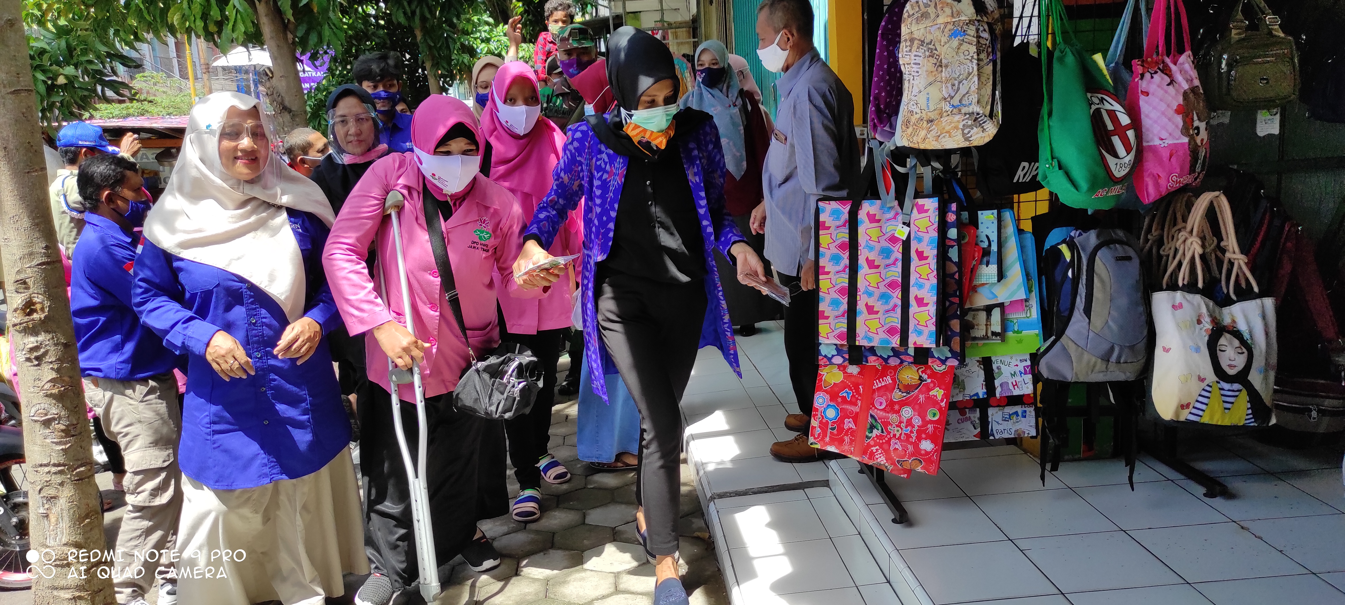 Isteri Walikota Kediri, Feronica dampingi penyandang disabilitas bagikan masker. (Foto: Fendhy Plesmana/Ngopibareng.id) 