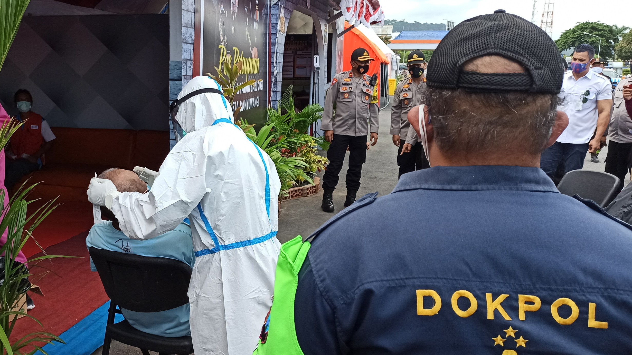 Salah seorang warga yang baru datang dari Bali diambil sampel lendirnya untuk dilakukan rapid test antigen di pintu keluar pelabuhan penyeberangan Ketapang, Banyuwangi (foto:Muh Hujaini/Ngopibareng.id)
