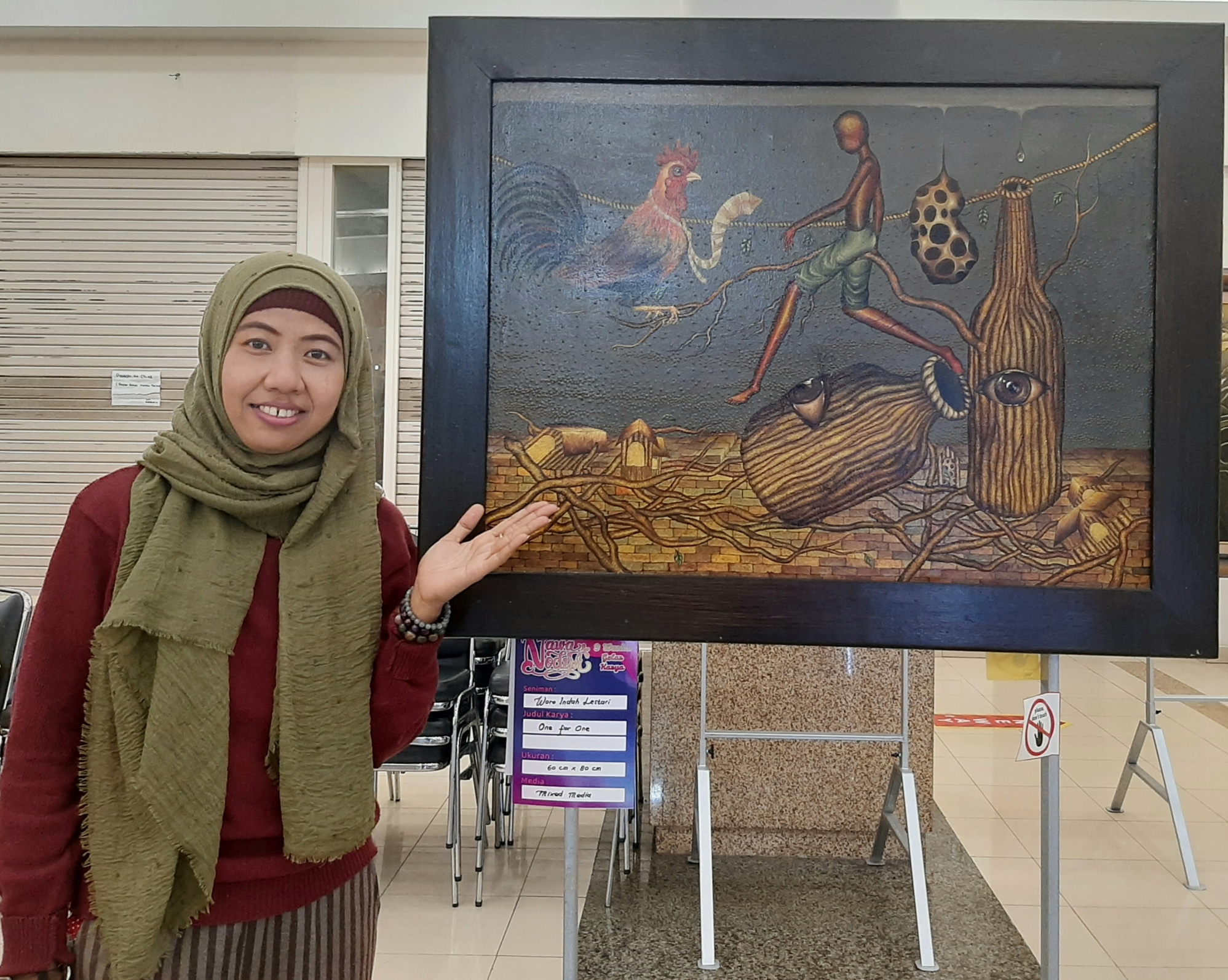 Salah satu pelukis Woro saat menunjukan karya seninnya yang dipamerkan tepat di hari ibu. (Foto: Pita Sari/Ngopibareng.id)