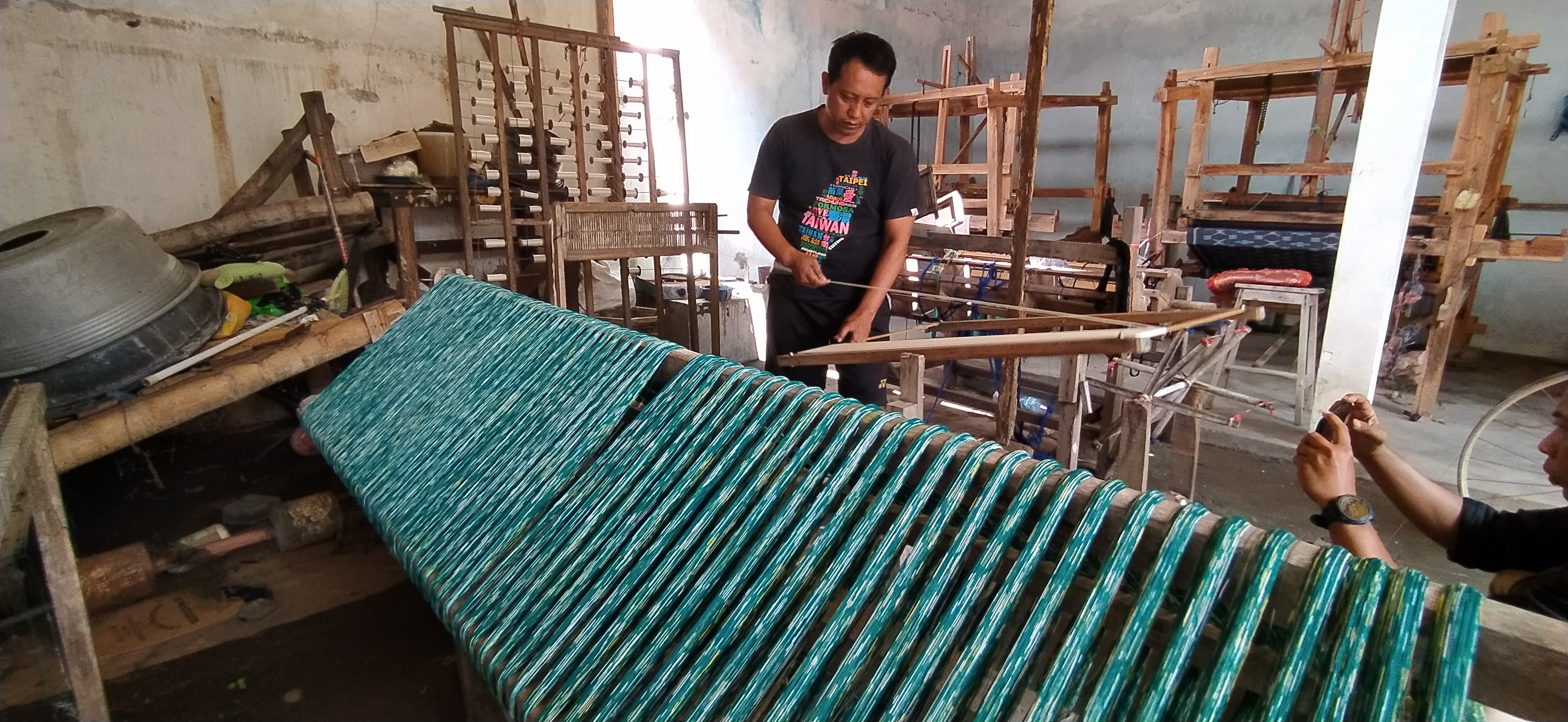 Cipto Roso, satpam di Kediri ini memiliki usaha produksi kain tenun ikat. (Foto: Fend/Ngopibareng.id)