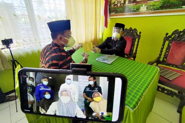 Prosesi ijab kabul di KUA Kecamatan Pakel, Tulungagung yang disaksikan pengantin wanita lewat online. (Foto: Ant)
