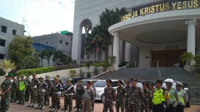 Sejumlah anggota Banser dan polisi tengah menjaga gereja di Surabaya. (Foto: Istimewa)