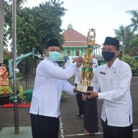 Kepala Kantor Kementerian Agama Kabupaten Nganjuk, Jawa Timur, Taufiqurrohman (kiri) menyerahkan trofi dalam peringatan HAB ke-75 Kemenag RI. (Foto: Istimewa)