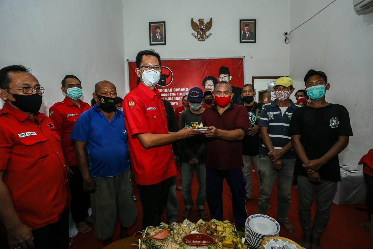 Ketua DPC PDI Perjuangan Kota Surabaya Adi Sutarwijono ketika membagikan tumpeng ke rakyat. (Foto: PDI Perjuangan Kota Surabaya)