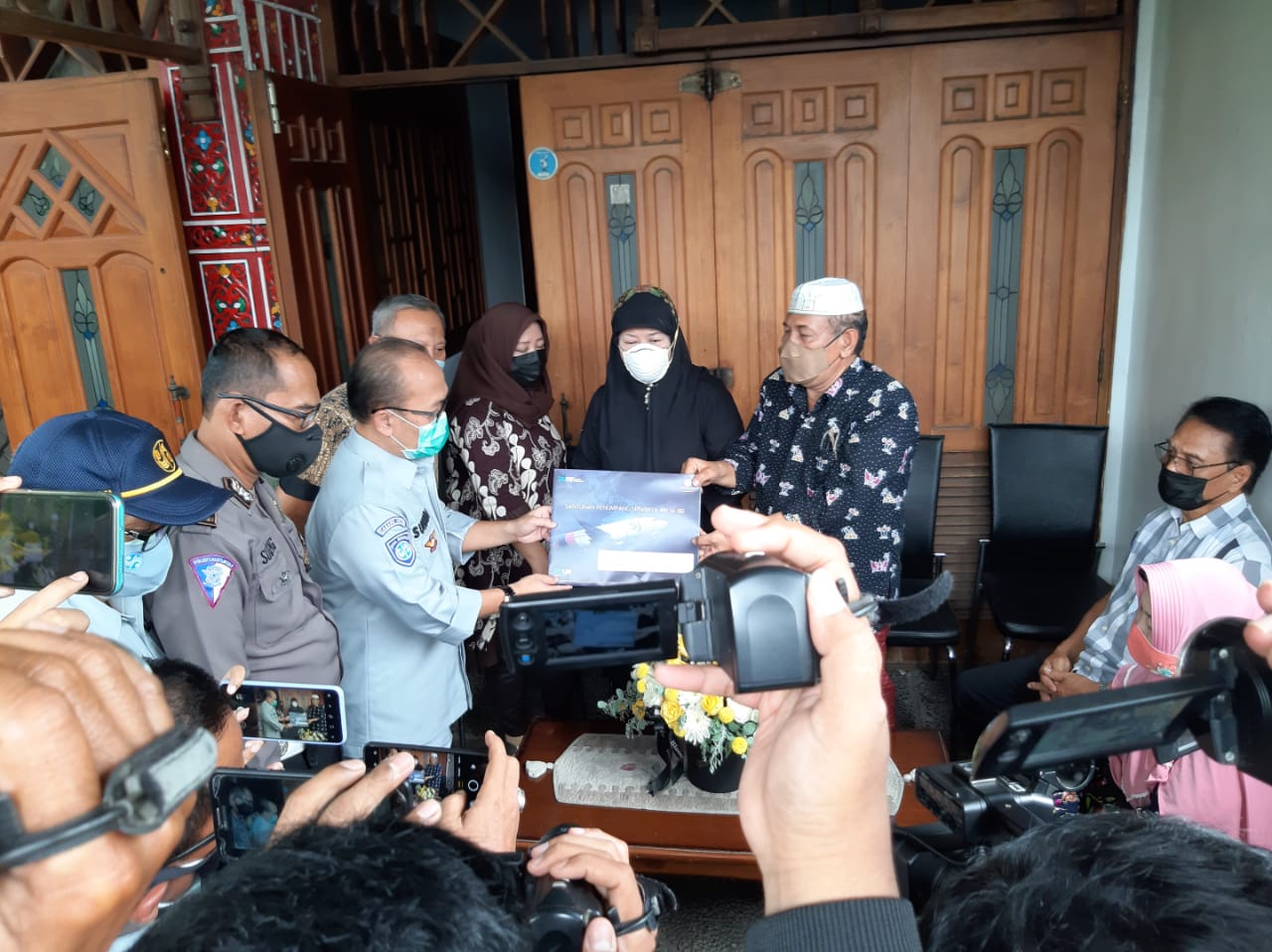 Ayah Fadly, Sumarzen Marzuki (kanan) menerima santunan dari PT Jasa Raharja dikediamannya Jalan Tanjung Pinang, Surabaya, Rabu 13 Januari 2021. 