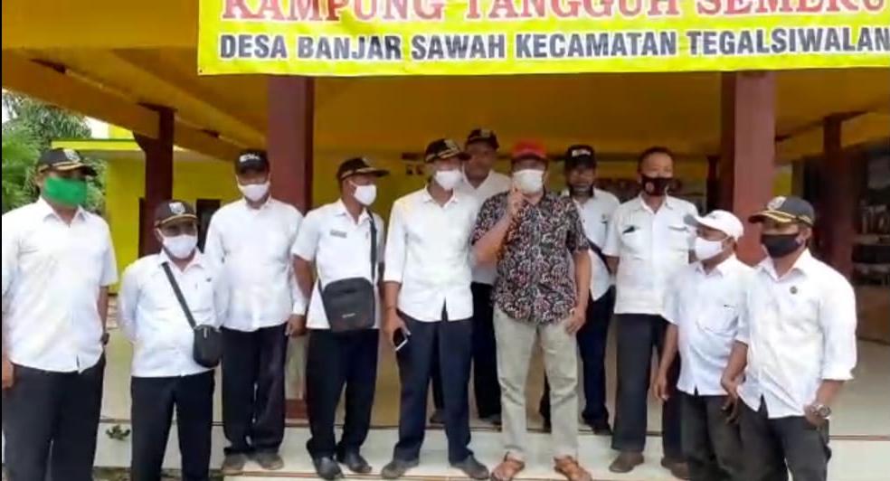 Kades Banjarsawah, M. Saleh (hem batik) bersama perangkat desa saat menyatakan maklumat via video. (Foto: tangkapan layar video).