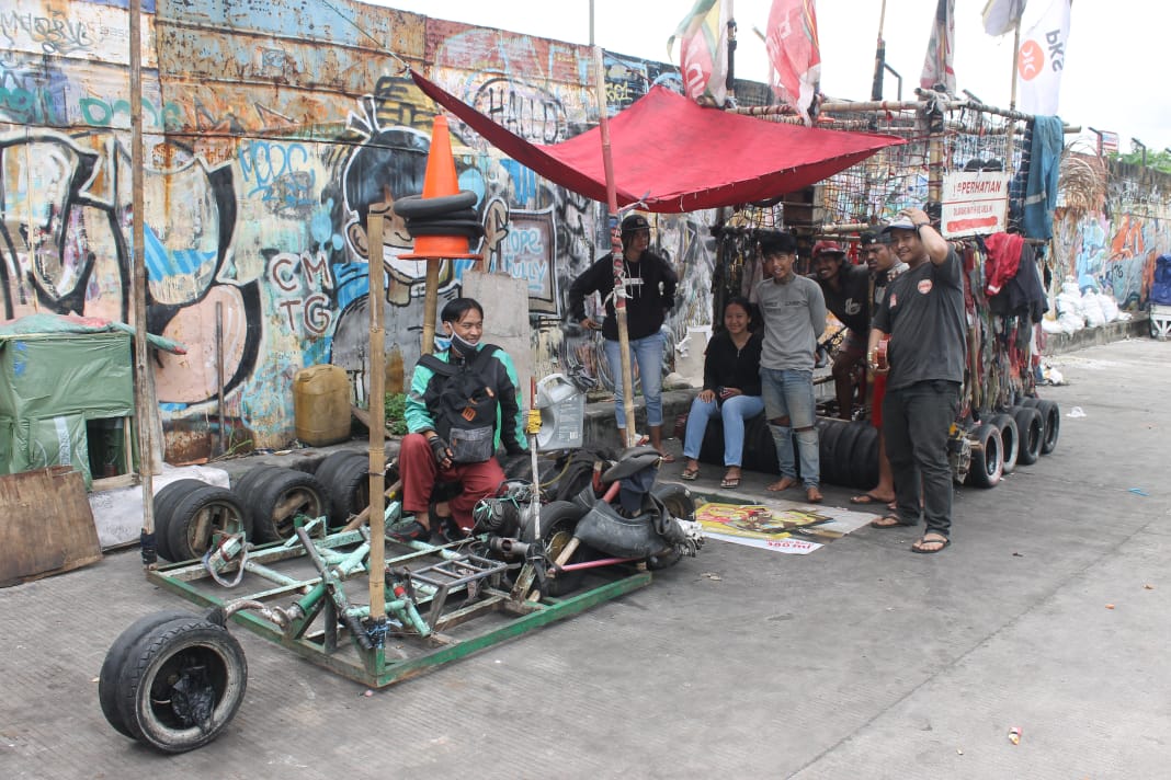 Komunitas penggemar Vespa sedanga memperbaiki mesin gerobaknya yang mengalami gangguan. ( Foto: Asmanu Sudharso/Ngopibareng.id)
