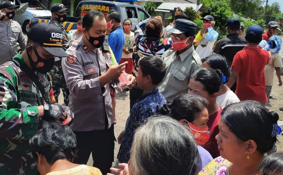 Kapolsek Songgon Iptu Eko Darmawan bersama Forpimka Kecamatan Songgon, membagikan masker kepada masyarakat di kaki Gunung Raung. (Foto: Istimewa) 