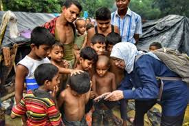 Seorang aktivis sosial sedang memberikan hiburan bagi anak-anak pengungsi Rohingya. (Foto: afp)