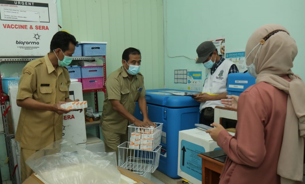Petugas dari Dinkes Kota Probolinggo memasukkan vaksin Covid-19 ke dalam lemari pendingin. (Foto: Ikhsan Mahmudi/Ngopibareng.id)