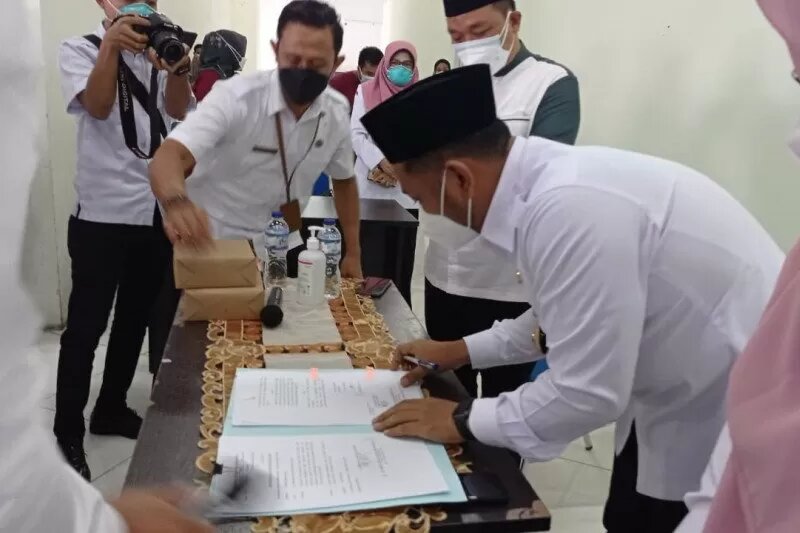 Bupati Gresik, Fandi Akhmad Yani menandatangani Perubahan Peraturan Bupati Nomer 23 tahun 2020 yang didalamnya termuat tentang insentif tenaga kesehatan di Gelora Joko Samudro, Rabu, 3 Maret 2021. (Foto: Humas Pemkab Gresik)