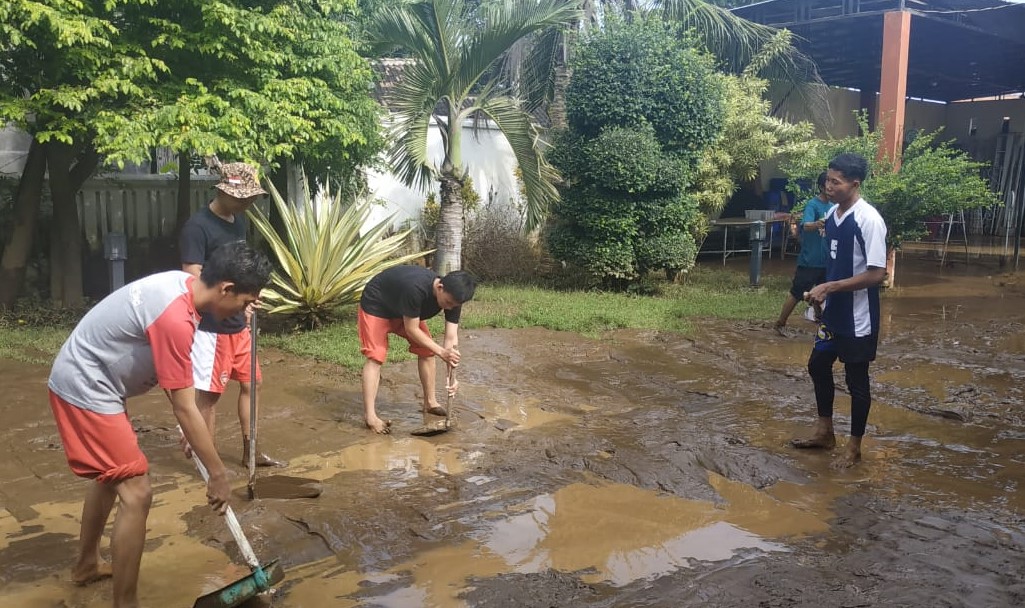 Warga Desa Kedungdalem, Kabupaten Probolinggo membersihkan endapan lumpur di sekitar rumahnya pasca banjir bandang. (Foto: Ikhsan Mahmudi/Ngopibareng.id)