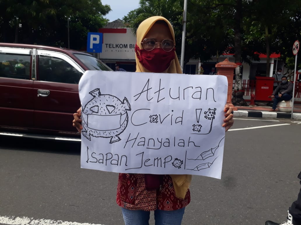 Salah satu mahasiswa di Blitar membentangkan poster protes atas kelakukan Walikota Blitar. (Foto: Choirul Anam/Ngopibareng.id)