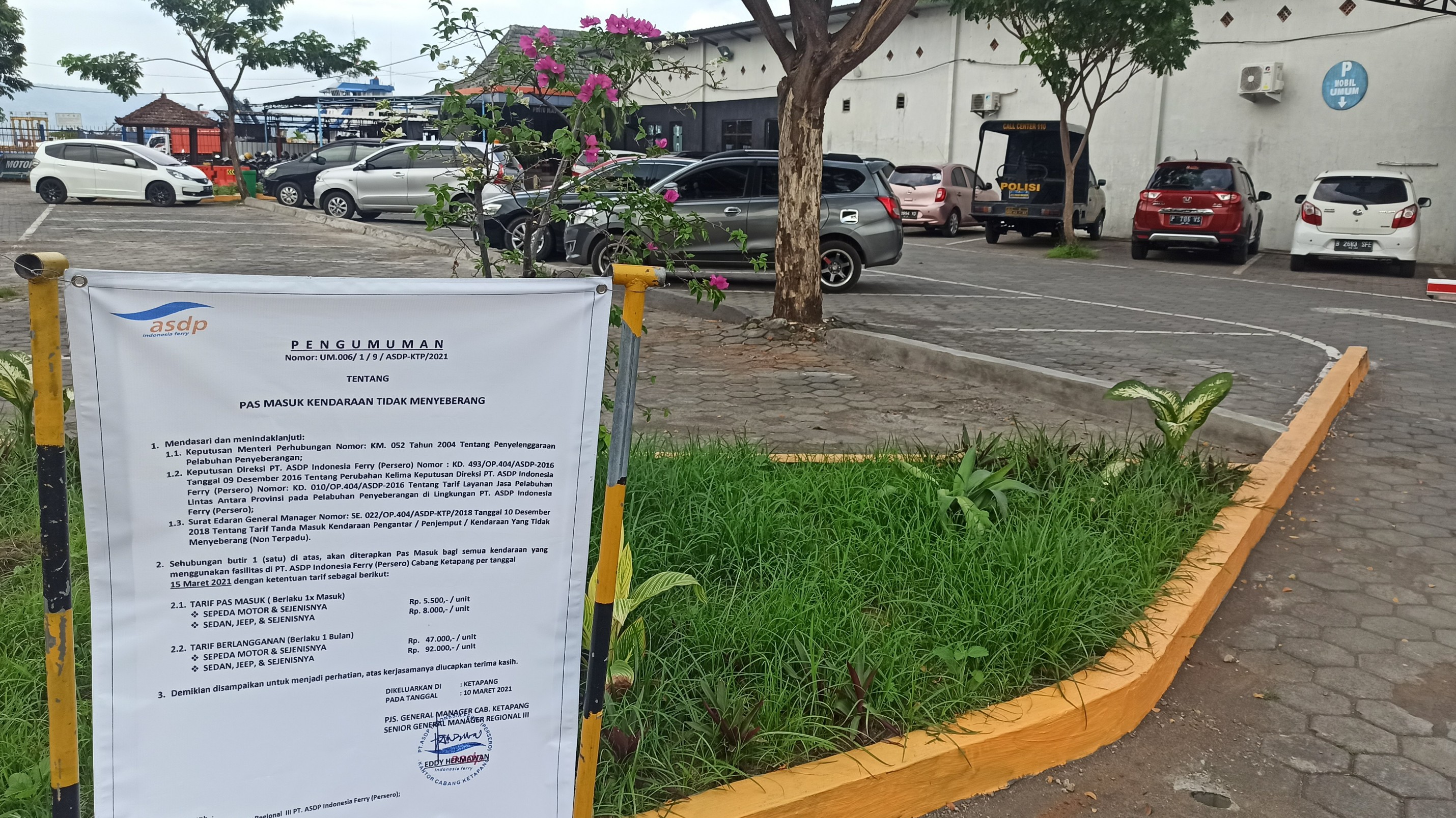 Pengumuman tentang pas masuk dipasang di pintu masuk area parkir di Pelabuhan Penyeberangan Ketapang, Banyuwangi. (Foto: Muh Hujaini/Ngopibareng.id)