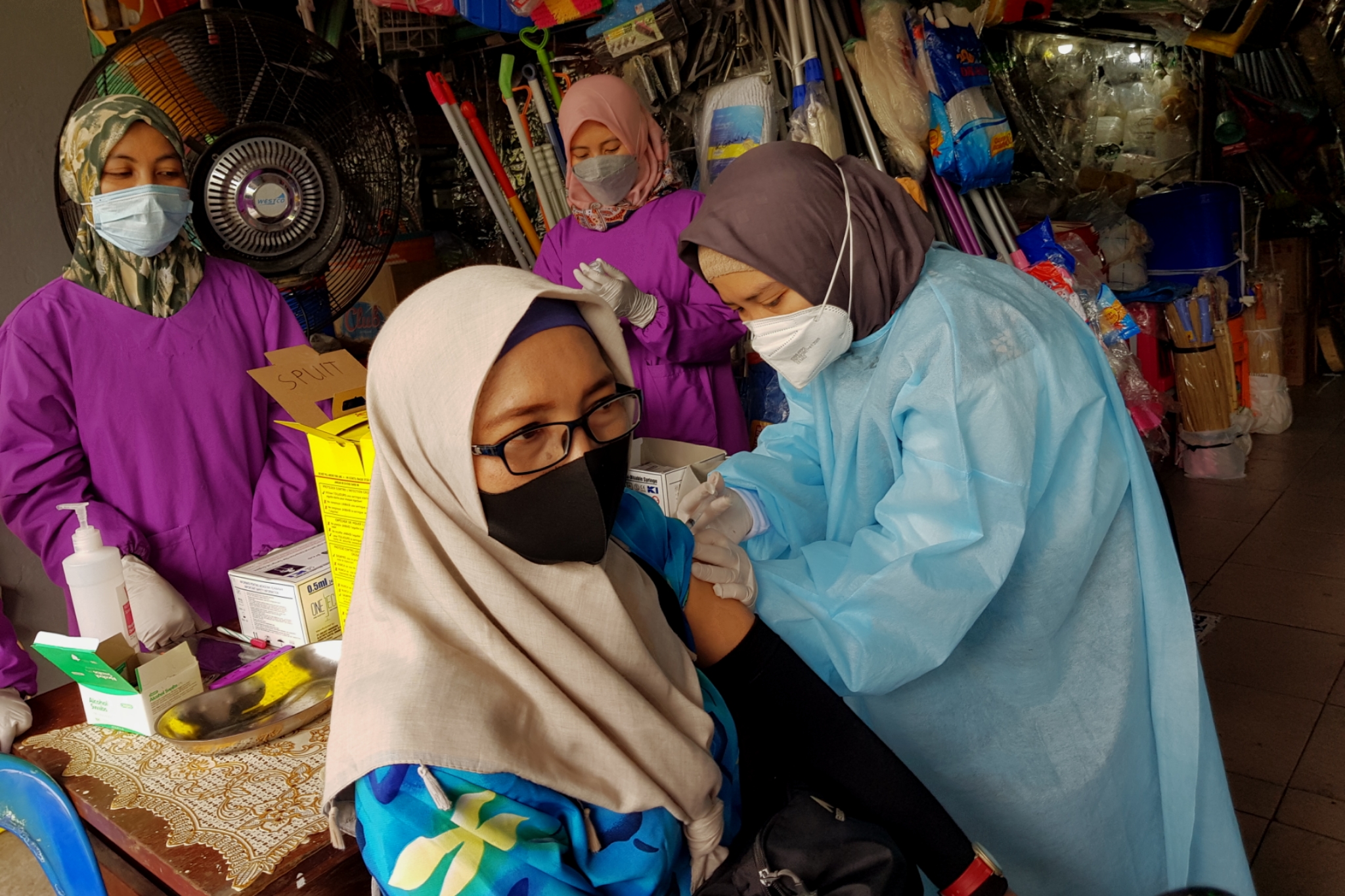 Salah satu pedagang menerima suntikan vaksin yanh dilakukan oleh petugas dari Puskesmas Genteng, di Pasar Genteng, Surabaya, Senin 29 Maret 2021. (Foto: Fariz Yarbo/Ngopibareng.id)