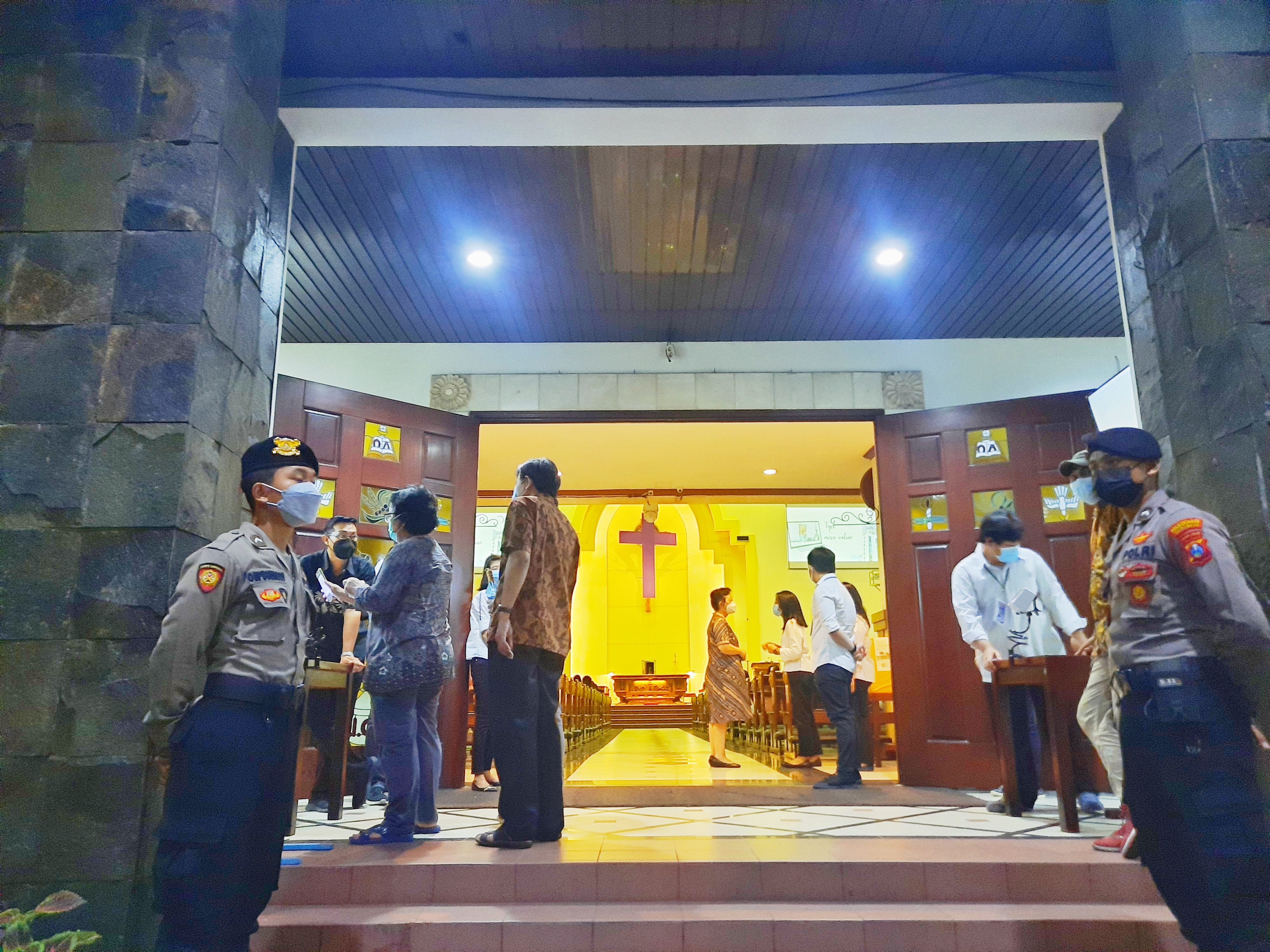 Personel Kepolisian yang menjaga pintu masuk Gereja Santa Maria Tak Bercela. (Foto: Alief Sambogo/Ngopibareng.id)