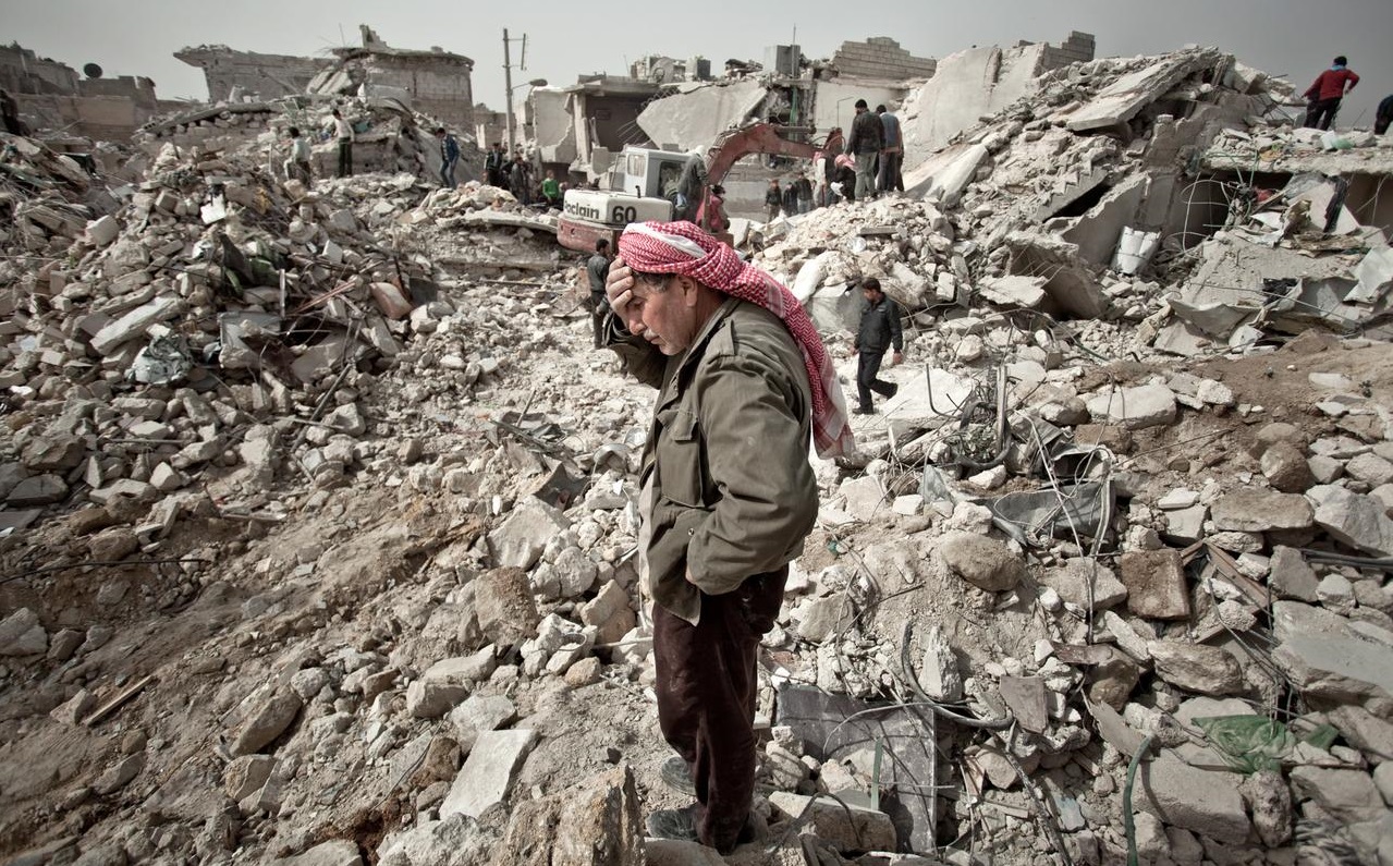 Warga Suriah berdiri di atas reruntuhan rumahnya. (Foto: Pablo Tosco/Narrative.ly)