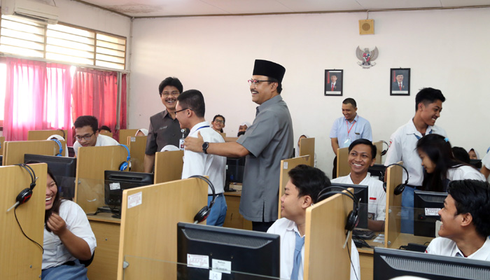 Wagub Jatim Saifullah Yusuf (Gus Ipul) memijat seorang pelajar sebelum mengikuti UNBK di SMKN 8 Surabaya