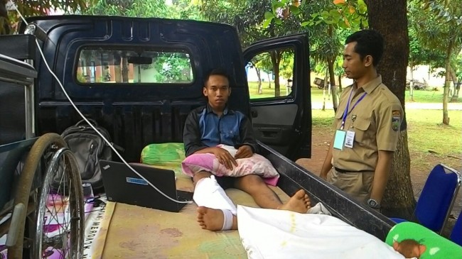 Reo Pradita, Siswa SMK Negeri 1 Jepara ini terpaksa mengerjakan soal di mobil di depan sekolah lantaran sakit akibat kecelakaan, Senin (3/4) pagi. (Foto: Metrotv News)