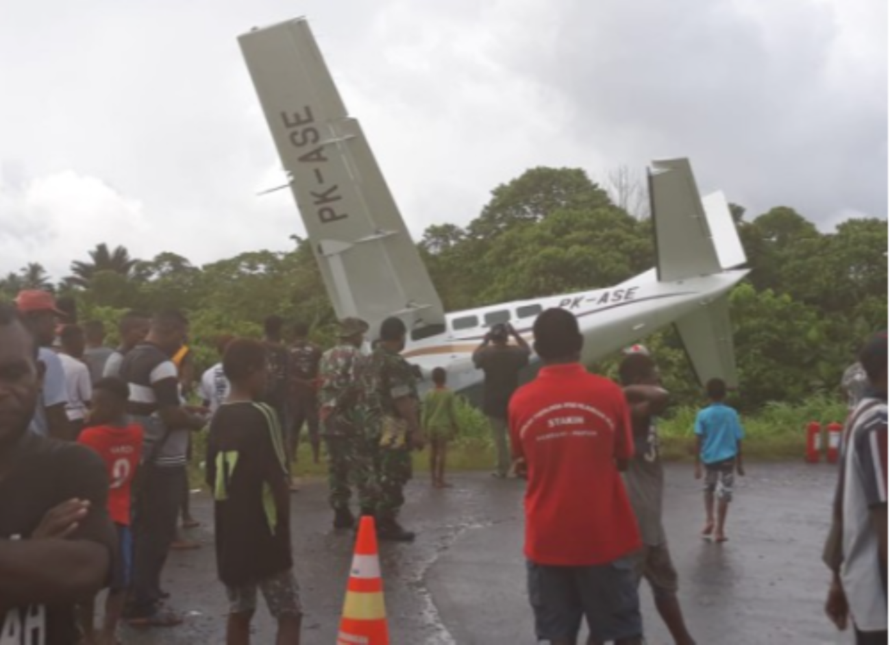 Badan pesawat Alfra Trans yang tergelincir saat mendarat di Bandara Kasonaweja, Mamberamo Tengah, Papua. Pesawat nyaris masuk jurang. (Foto: beritatrans.com)