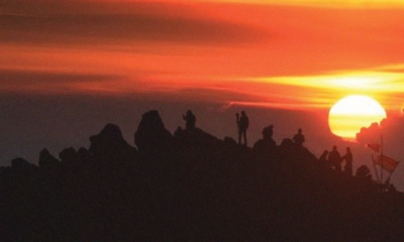 Pendaki menikmati matahari terbit di puncak Gunung Arjuno, Pasuruan, Jawa Timur, Minggu (24/4). Gunung Arjuno adalah sebuah gunung berapi kerucut di Jawa Timur, dengan ketinggian 3.339 m dpl dan merupakan salah satu tujuan pendakian di Indonesia. (Foto: Antara/Zabur Karuru)