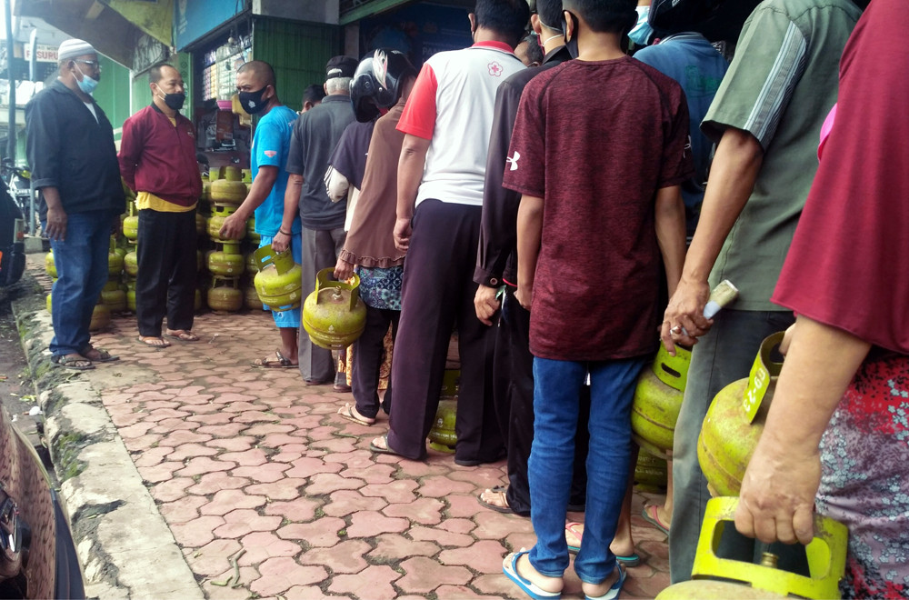 Antrean warga yang mengular untuk membeli gas elpiji 3 kg harga bersubsidi atau HET di salah satu kios resmi di Bondowoso. (Foto: Guido Saphan/Ngopibareng.id)