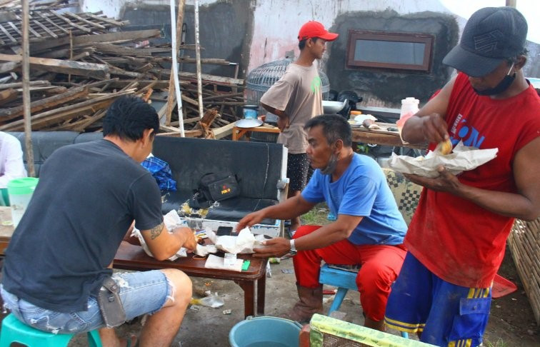 Warga korban gempa Malang buka puasa di antara puing-puing reruntuhan bangunan rumahnya. (Foto: Ant)