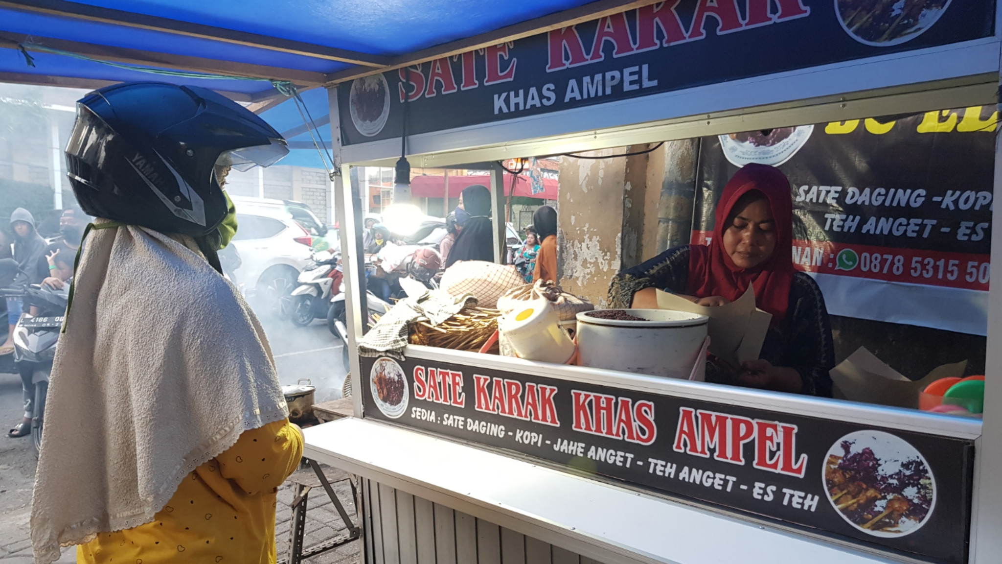 Elis saat menyajikan sate karak pesanan pembeli. (Foto: Fariz Yarbo/Ngopibareng.id)