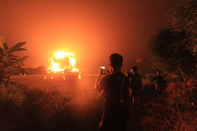 Warga menyaksikan kebakaran di kompleks Pertamina RU VI Balongan, Indramayu, Jawa Barat, Senin, 29 Maret 2021 dini hari. (Foto: Antara/Dedhez Anggara)