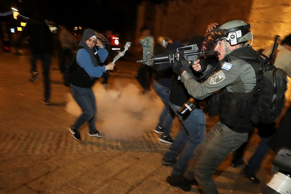Petugas polisi Israel di posisi siaga saat granat setrum meledak di dekat gerbang ke Kota Tua Yerusalem selama bentrokan, saat bulan suci puasa Ramadhan berlanjut, di Yerusalem 24 April 2021. (Foto: reuters)