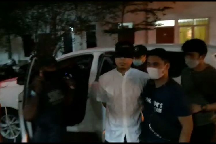 Munarman saat digelandang ke Mapolda Metro Jaya, mata ditutup kain hitam dan tangan diborgol. (Foto: Kompas)