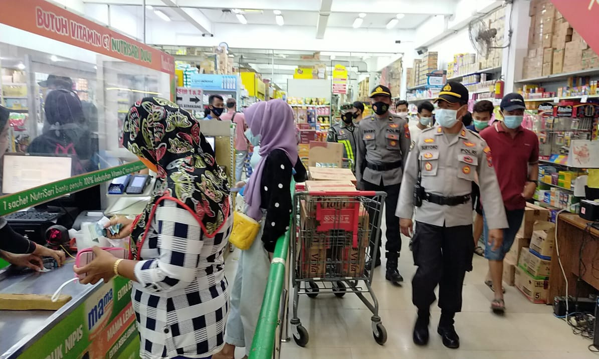 Petugas melakukan patroli di salah satu pusat perbelanjaan di wilayah kecamatan Gambiran untuk memastikan protokol kesehatan telah diterapkan secara baik (foto:istimewa)