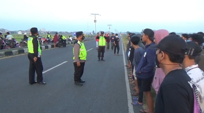 Petugas Polsek Mojoagung menertibkan puluhan remaja yang tengah balap liar di Ring Road Mojoagung, Minggu 2 Mei 2021. (Foto: istimewa)