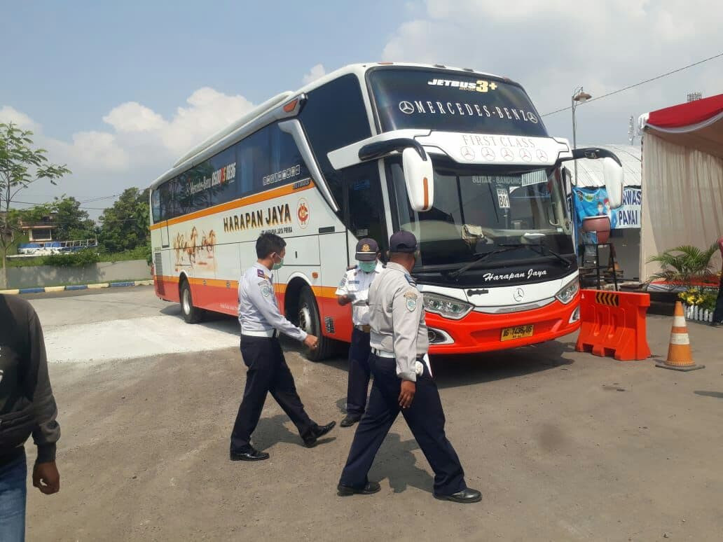 Petugas Terminal Patria di Blitar akan memberikan stiker khusus pada bus yang boleh beroperasi selama masa larangan mudik. (Foto: Choirul Anam/Ngopibareng.id)