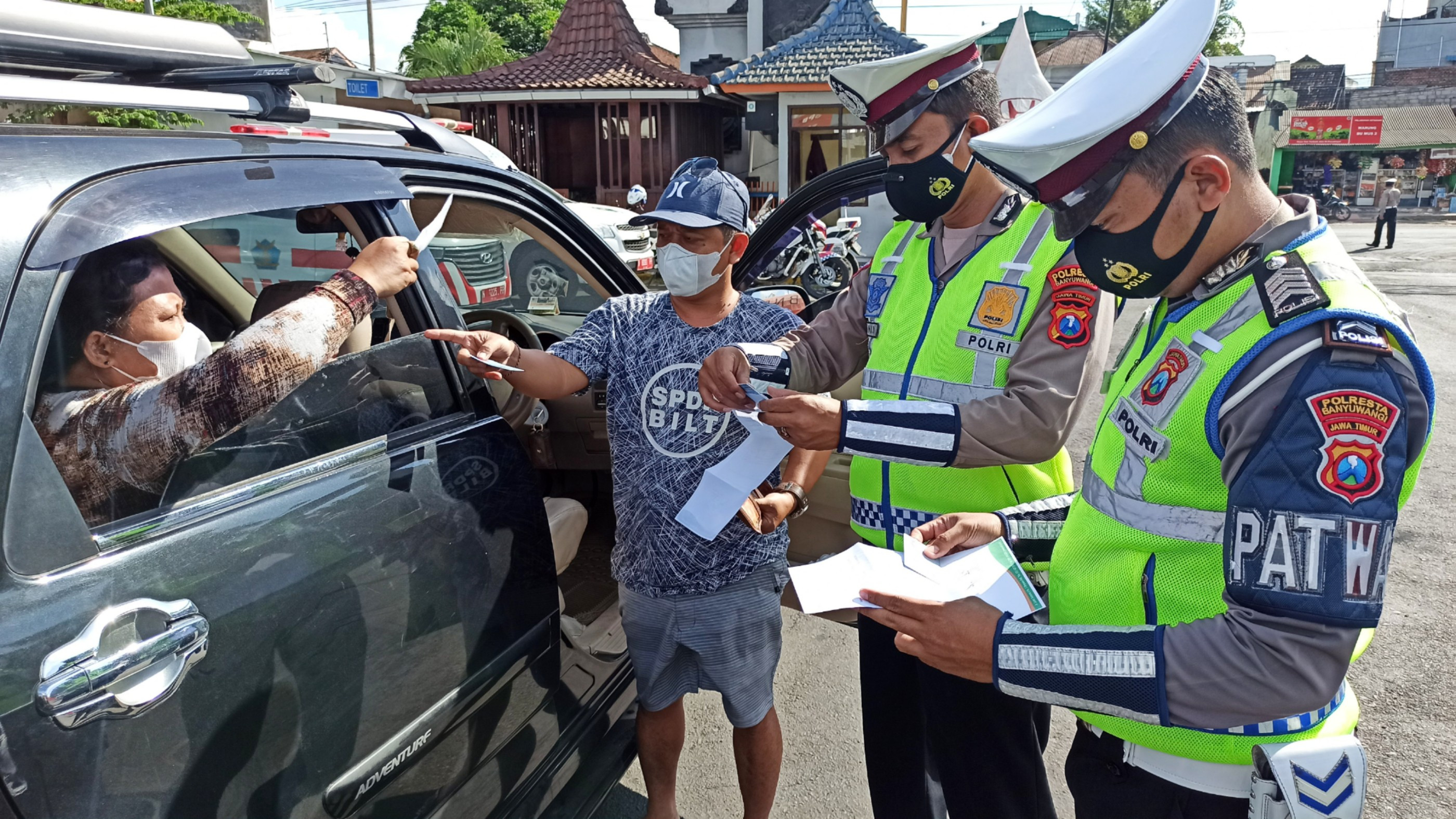 Petugas Kepolisian memeriksa surat keterangan bebas covid-19 penumpang kendaraan dari Bali yang masuk ke Jawa Timur melalui Pelabuhan Ketapang, Banyuwangi (foto:Muh Hujaini/Ngopibareng.id)